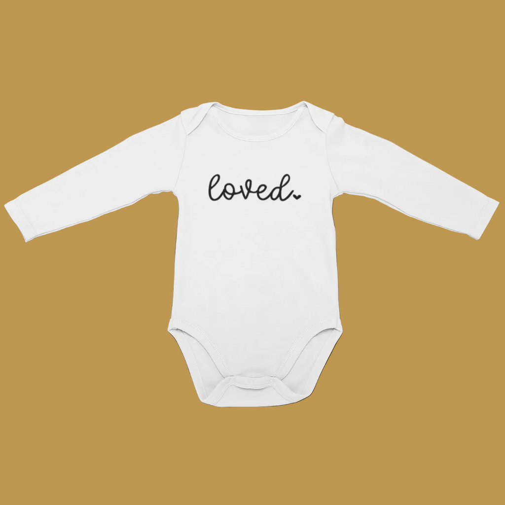 White long sleeve baby grow with Loved printed in black script, laid flat on a tan background.