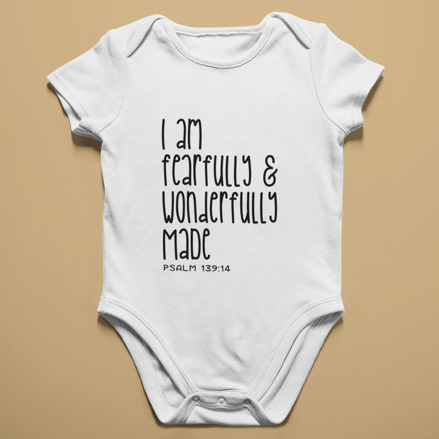 White short sleeve baby grow printed with I Am Fearfully and Wonderfully Made, Psalm 139:14, laid flat.