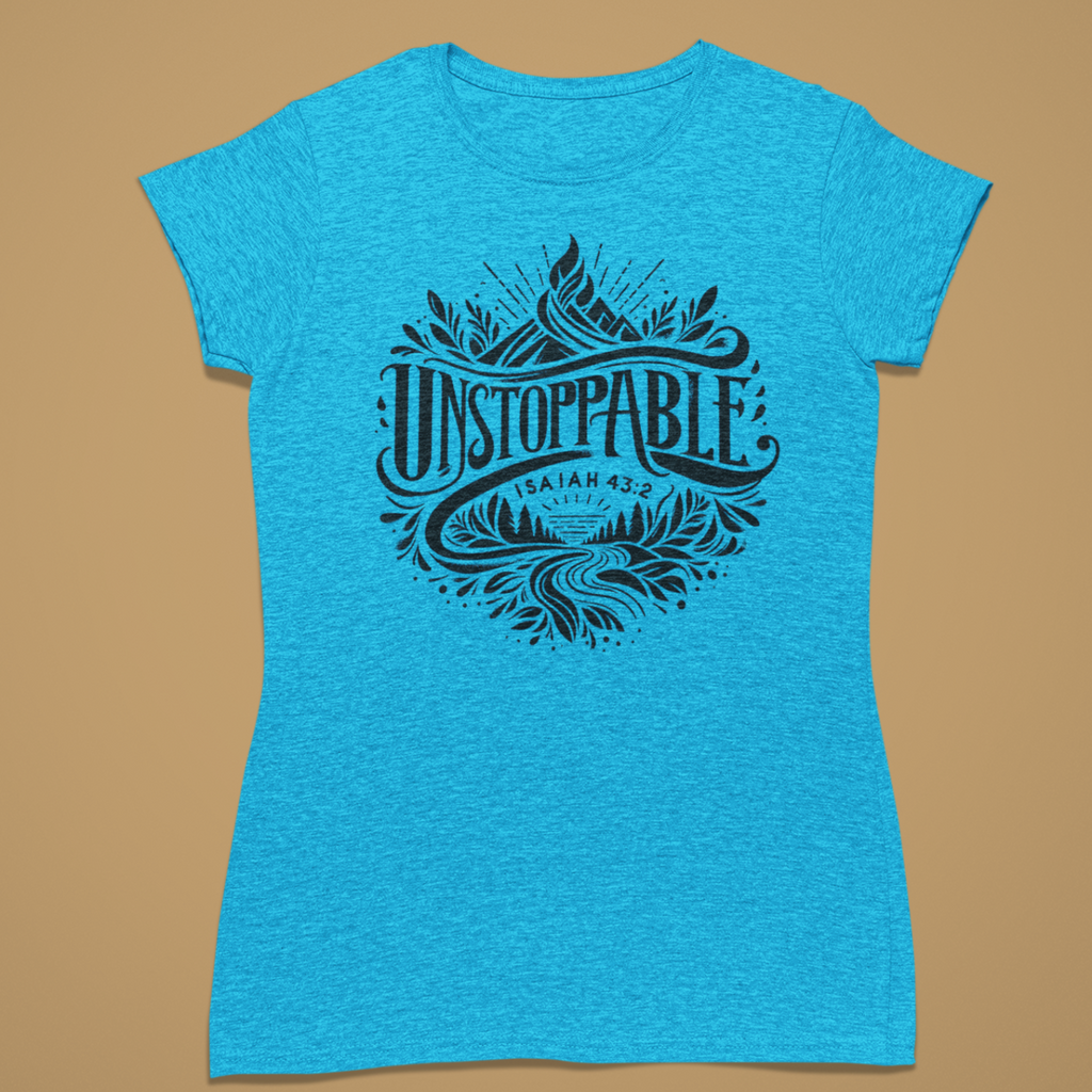 A women's short-sleeve t-shirt in heathered bright blue, featuring a dark navy graphic print on the front with the words 'UNSTOPPABLE', 'UTAH', and a mountain and leaf design, displayed against a solid tan background.